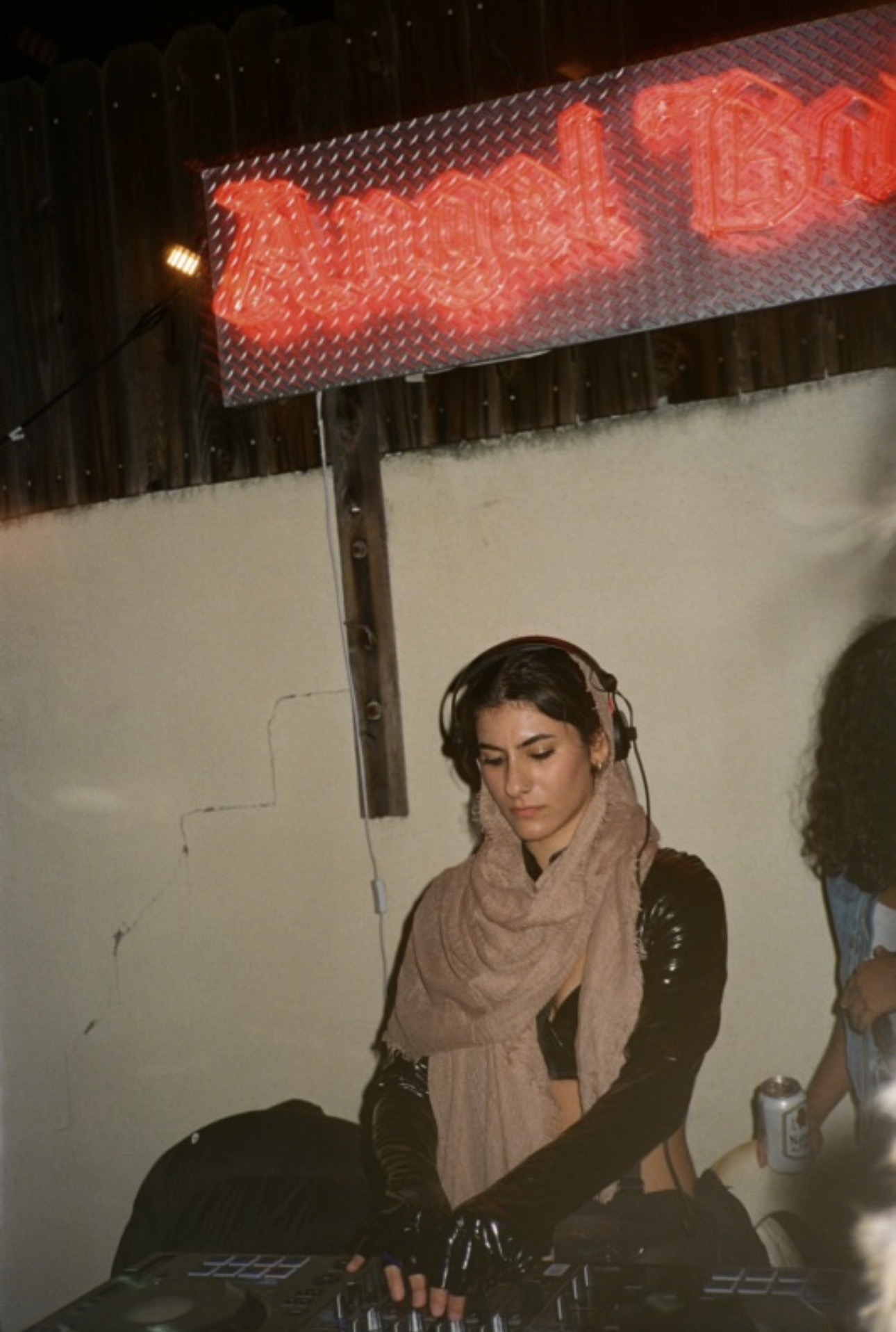 Melody.MP3 playing an outdoor night set under a neon sign