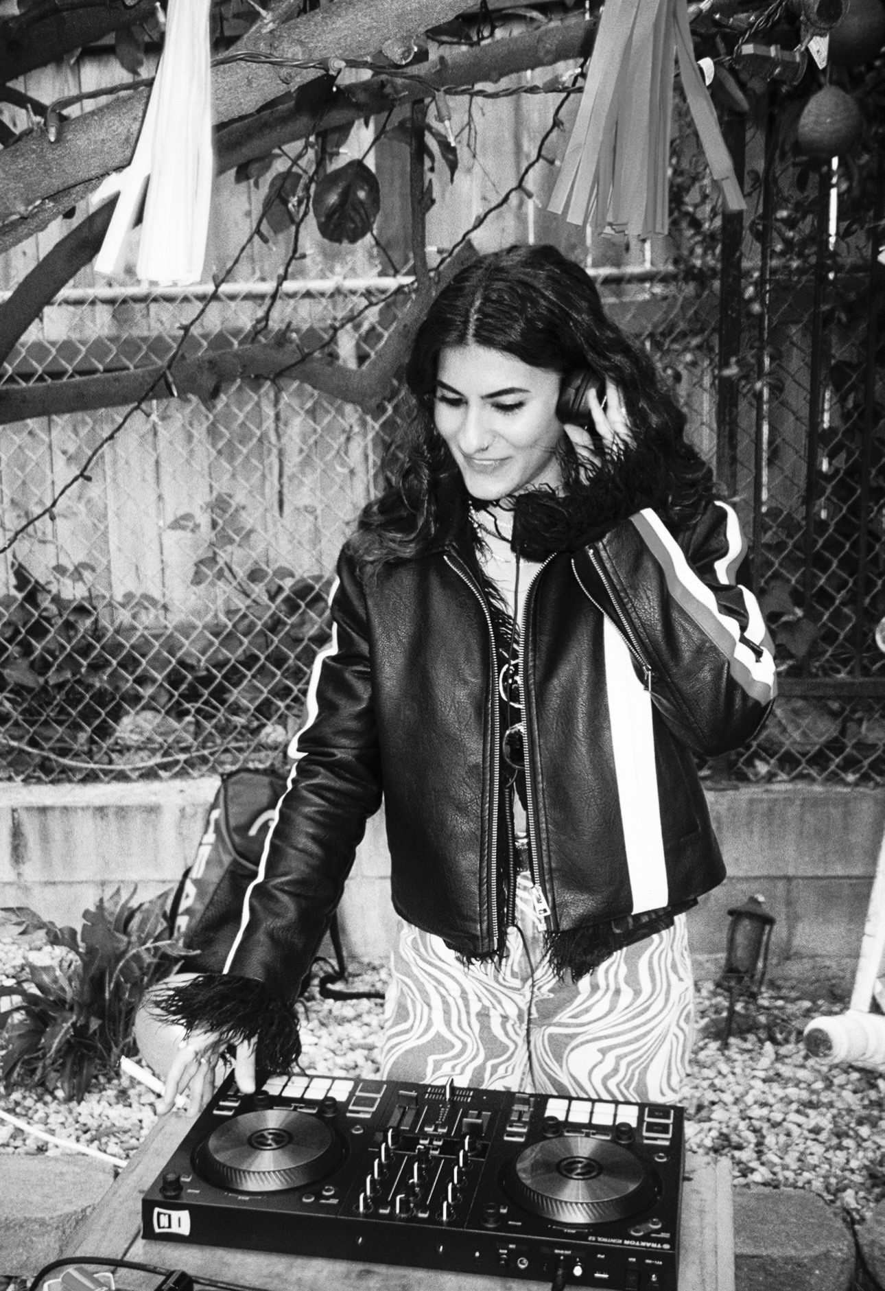 Melody.MP3 mixing outdoors in a leather jacket